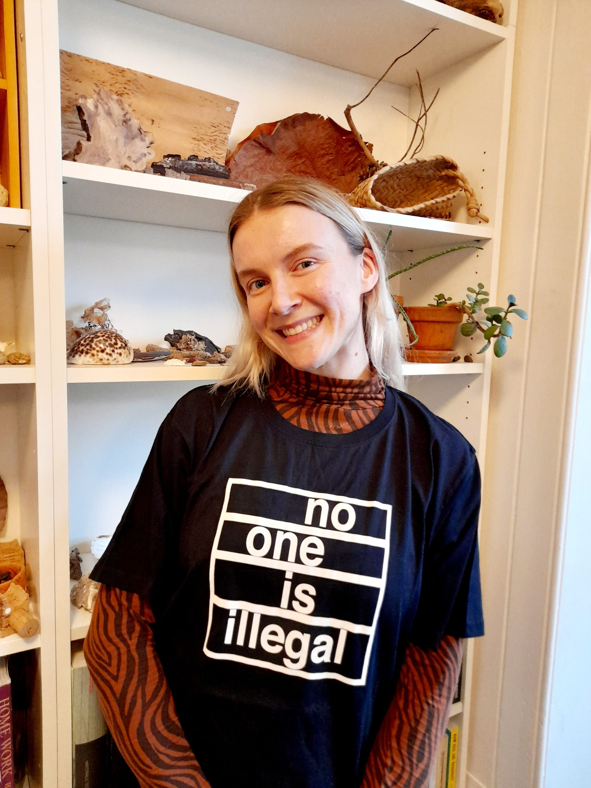 A photo of Esther standing in Right to Remain office.